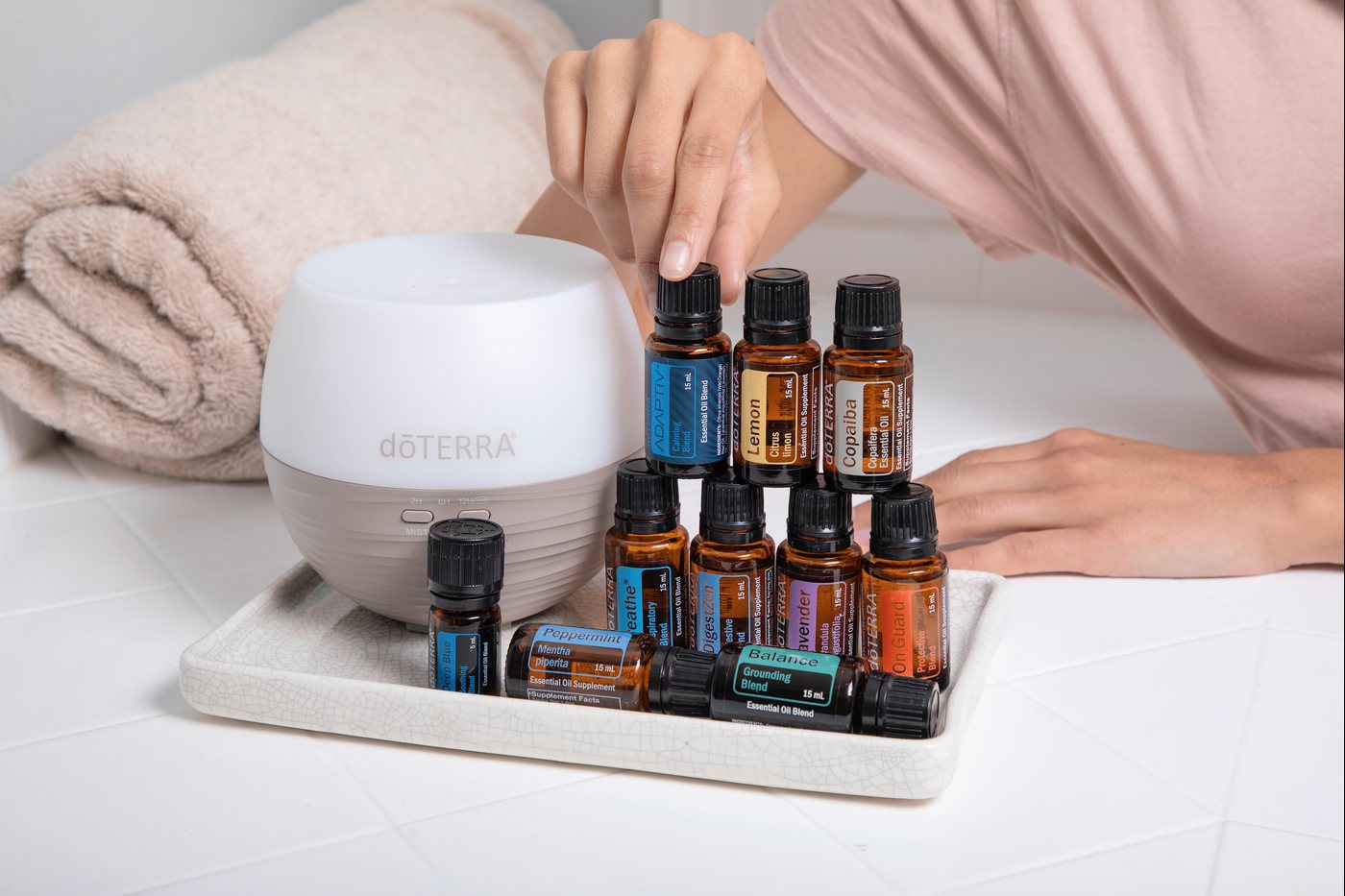 A dōTERRA diffuser and oil bottles on a tray