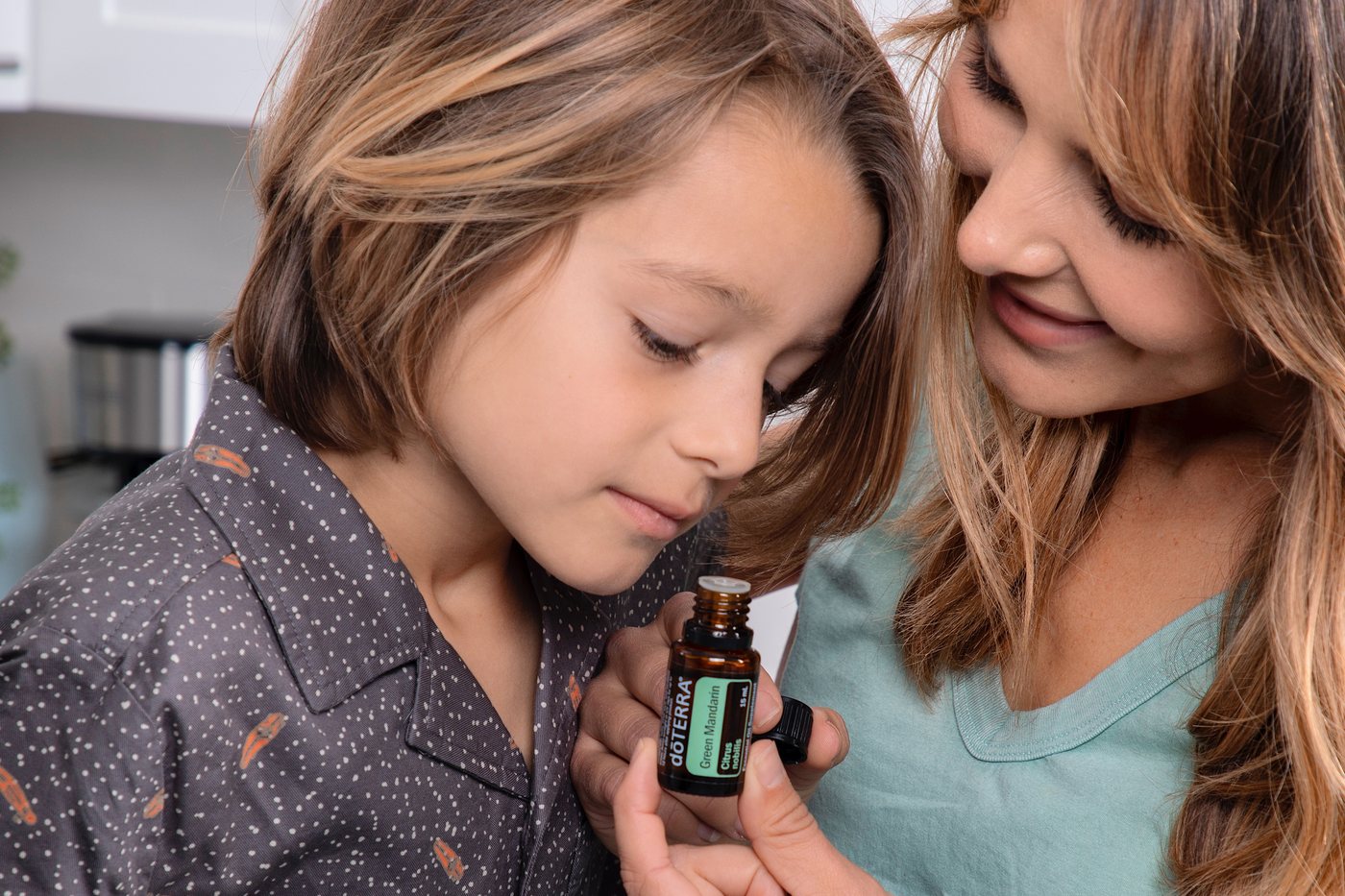 Mãe e filho a cheirar um frasco dōTERRA