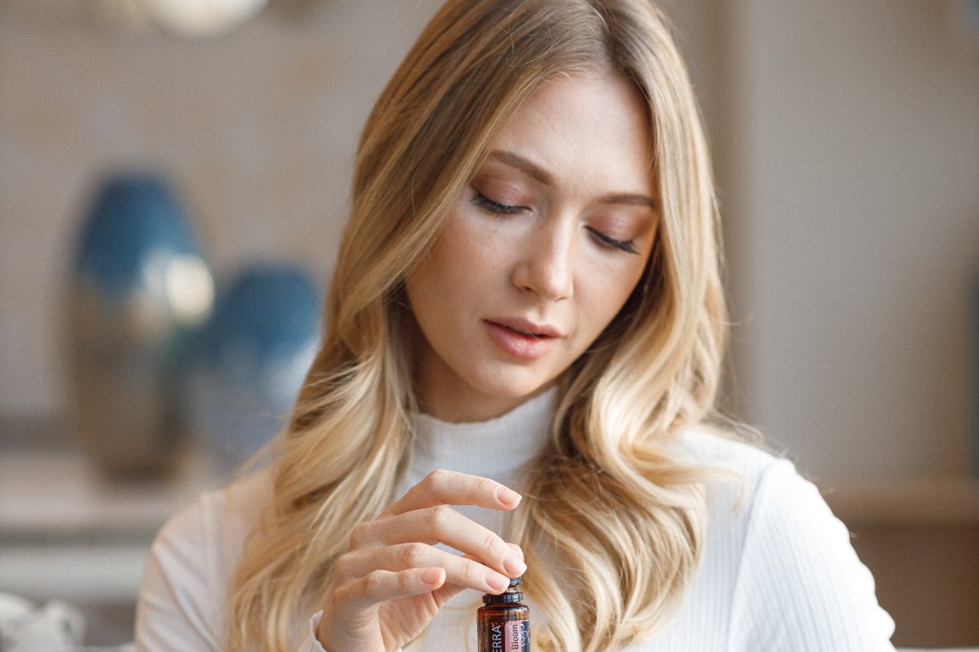 Eine Frau öffnet ein Fläschchen ätherisches Öl von dōTERRA